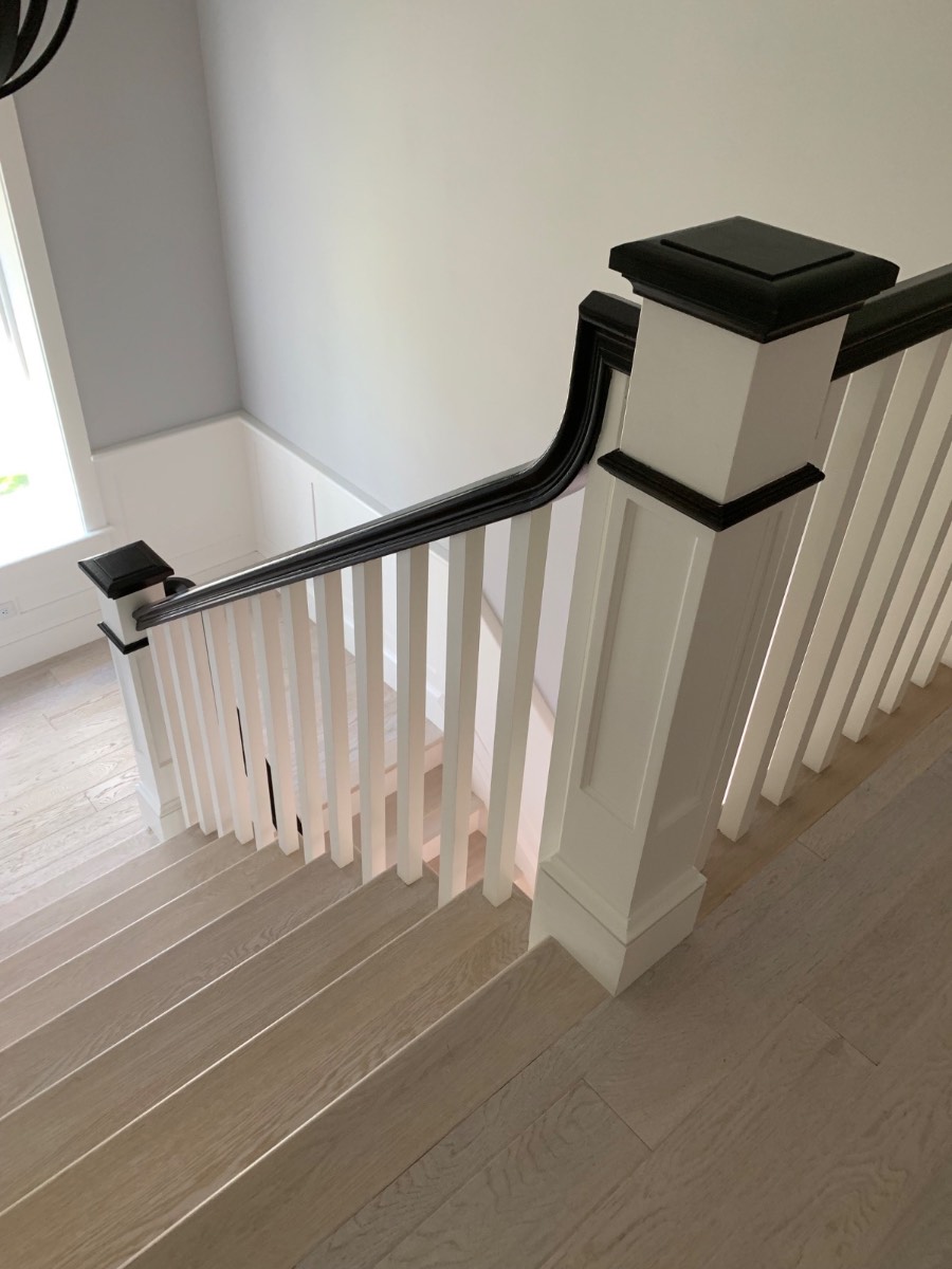 Custom staircase newel post and black handrail