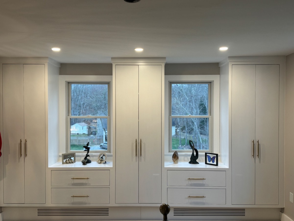 Custom white built-in wardrobe wall in a Cape Cod bedroom
