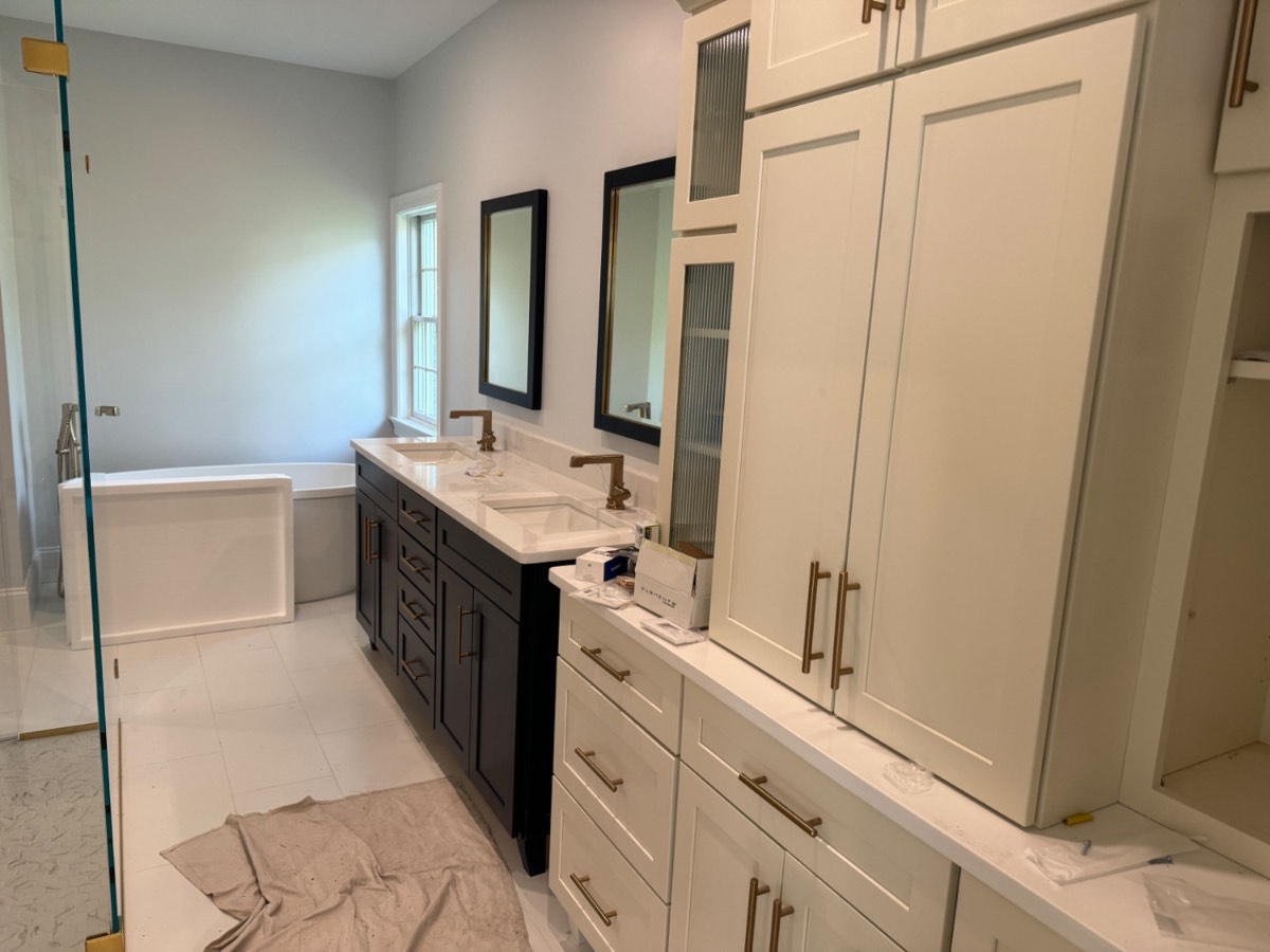 Custom master bathroom with dark double vanity and linen tower