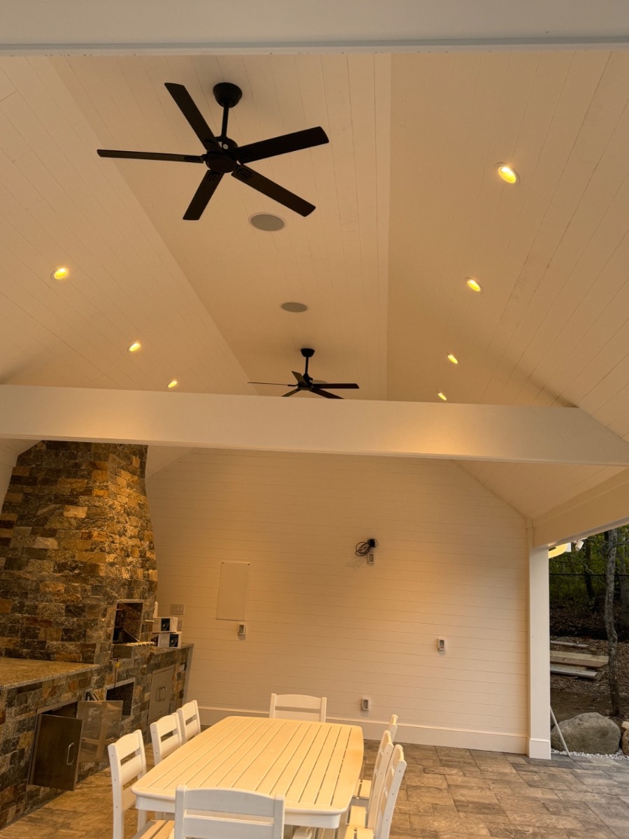 Custom pool house interior with vaulted shiplap ceiling and stone fireplace