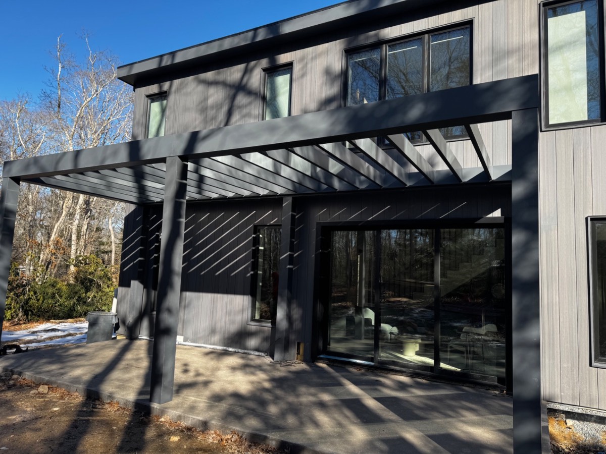 Modern black home with custom pergola and cedar siding
