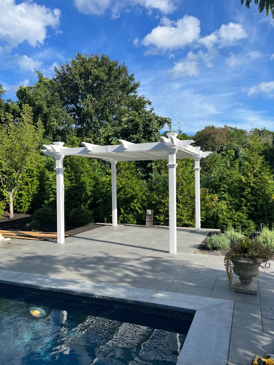 Custom white pergola beside a pool