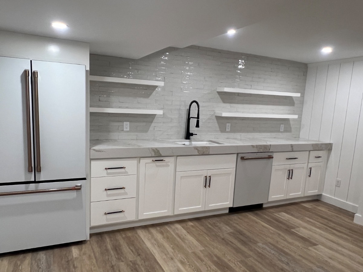 Custom white kitchen with floating shelves and marble