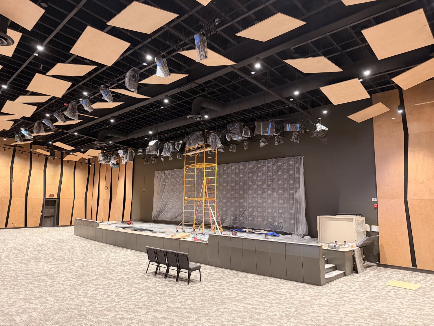 Finished auditorium at Reach Church — acoustic wood ceiling and wall paneling