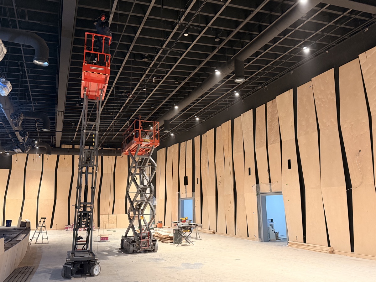 Curved acoustic wood wall paneling being installed at Reach Church